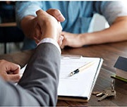 people shaking hand after signing a document